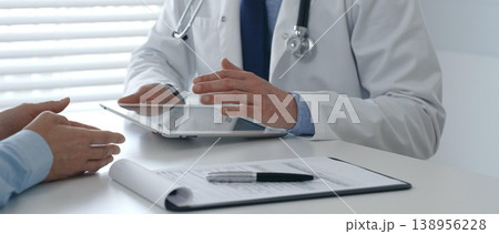 Male doctor sharing information with patient on a digital tablet during consultation, enhancing communication in healthcare. Medicine and health care concept Male doctor sharing information with patient on a digital tablet during consultation, enhancing communication in healthcare. Medicine and health care concept 138956228