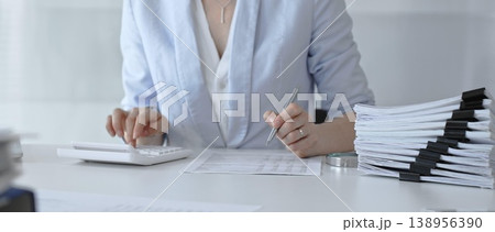 Professional woman calculating taxes, managing budget and financial paperwork, analyzing corporate accounting data, planning business finance strategies in modern office. Audit and taxes Professional woman calculating taxes, managing budget and financial paperwork, analyzing corporate accounting data, planning business finance strategies in modern office. Audit and taxes 138956390
