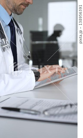 Doctor man interacting with patient during consultation, using digital tablet for modern medical healthcare technology. Medicine, healthcare and science concept 138956391