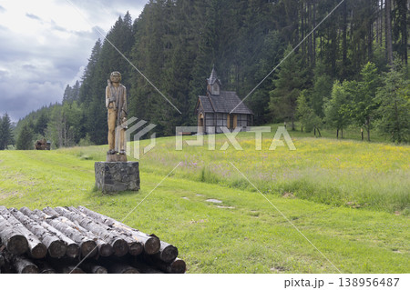 Wooden sculpture and chapel in natural mountain forest Wooden sculpture and chapel in natural mountain forest 138956487