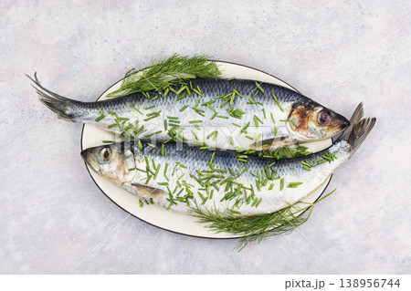 Fresh salted herring with herbs on plate 138956744