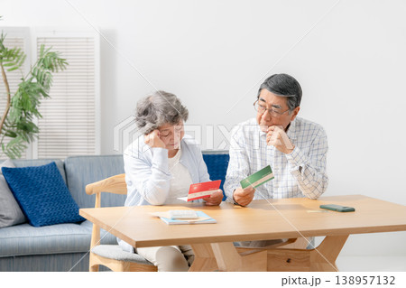 通帳を見て考えるシニア夫婦 138957132