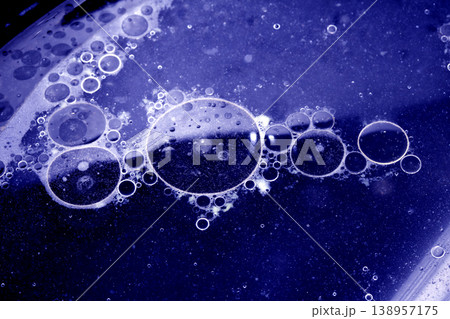Close up of grease oil bubbles in water abstract blue background Close up of grease oil bubbles in water abstract blue background 138957175