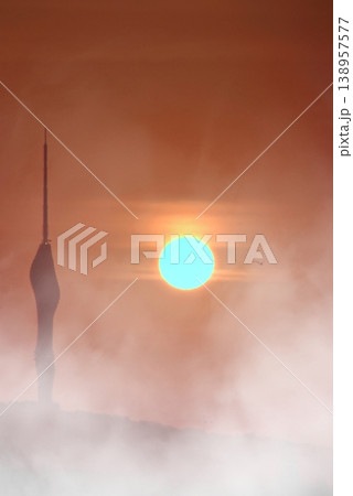 Ethereal Sunrise over Camlica Tower in Fog. A cinematic view of Istanbul's Camlica Tower silhouetted against a glowing sun and dense mist during a dramatic sunrise. 138957577