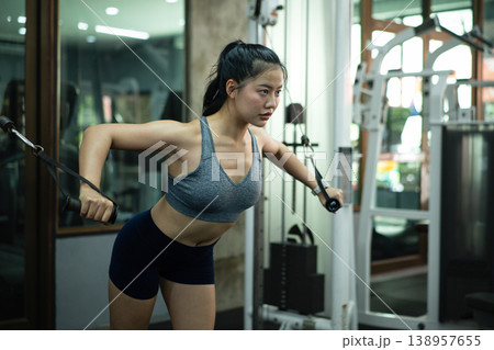 A woman exercise chest workout on cable chest press machine, Fitness and workout concept A woman exercise chest workout on cable chest press machine, Fitness and workout concept 138957655