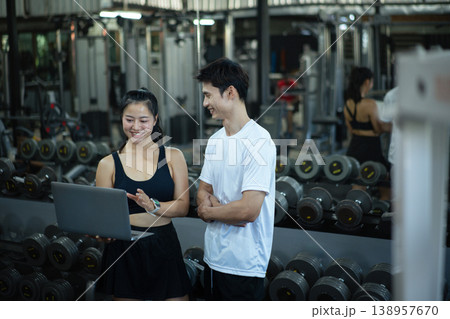 A woman trainer is discussing and reviewing physical progress with laptop A woman trainer is discussing and reviewing physical progress with laptop 138957670