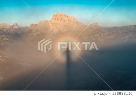 Rare circular rainbow glory and Brocken spectre over misty mountain in the morning 138958116