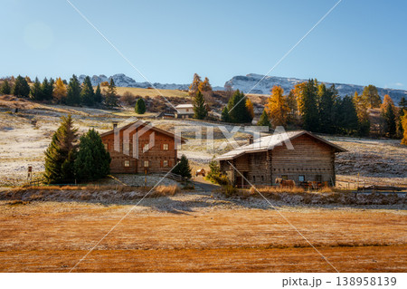 Idyllic autumn rustic wooden cabins on hill in scenic mountain Idyllic autumn rustic wooden cabins on hill in scenic mountain 138958139