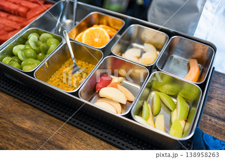 Fresh sliced fruits in stainless steel tray at juice bar counter Fresh sliced fruits in stainless steel tray at juice bar counter 138958263