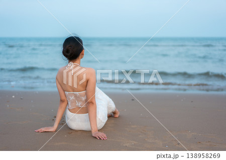 Serene woman relaxing on the beach during morning in tropical sea Serene woman relaxing on the beach during morning in tropical sea 138958269