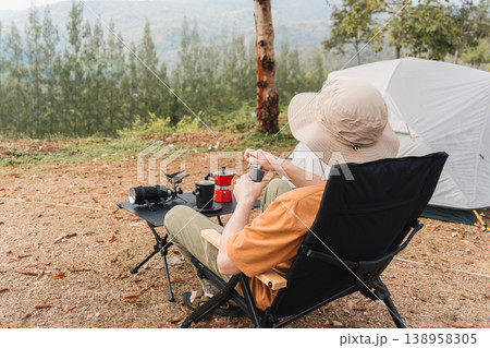 Man making espresso coffee with moka pot and coffee maker while camping mountain Man making espresso coffee with moka pot and coffee maker while camping mountain 138958305