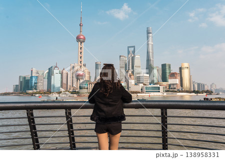 Female tourist looking at Oriental Pearl Tower and Shanghai financial skyscraper Female tourist looking at Oriental Pearl Tower and Shanghai financial skyscraper 138958331