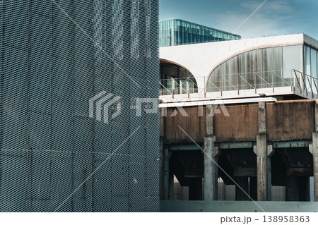 Metallic perforated mesh texture wall with arched glass windows, aged concrete structure building Metallic perforated mesh texture wall with arched glass windows, aged concrete structure building 138958363