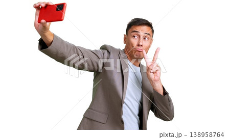 Man making funny face showing v sign taking selfie Man making funny face showing v sign taking selfie 138958764