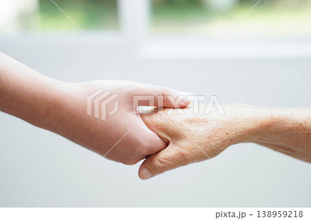 Caregiver holding hands Asian elderly woman patient, help and care in hospital. Caregiver holding hands Asian elderly woman patient, help and care in hospital. 138959218