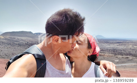 Couple kissing during hike in volcanic Timanfaya National Park Couple kissing during hike in volcanic Timanfaya National Park 138959289