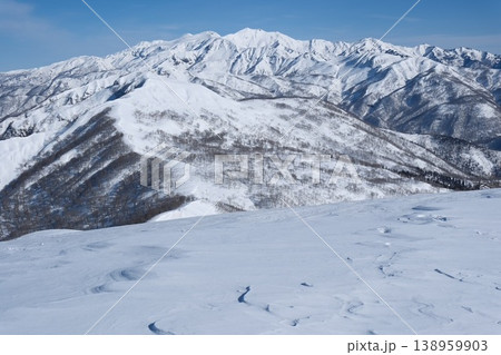 厳冬期の山頂から望む真っ白な連峰と雪山風景 雪原の紋様と遠く連なる稜線の情景 厳冬期の山頂から望む真っ白な連峰と雪山風景 雪原の紋様と遠く連なる稜線の情景 138959903