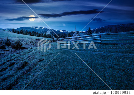 mountainous countryside landscape in spring at night. full moon over wooden fence and grassy meadow on a green hill. distant mountain ridge with snow capped tops. mysterious cloudy sky mountainous countryside landscape in spring at night. full moon over wooden fence and grassy meadow on a green hill. distant mountain ridge with snow capped tops. mysterious cloudy sky 138959932