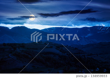 mountainous countryside scenery at night. full moon over dark sky view above the valley. green fields and trees on the hills. mysterious nature scenery of carpathian mountains mountainous countryside scenery at night. full moon over dark sky view above the valley. green fields and trees on the hills. mysterious nature scenery of carpathian mountains 138959933