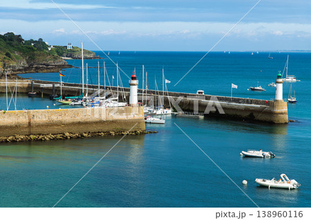 Summer Harbor With Twin Lighthouses, Marina and Sailboats Docked Along a Stone Breakwater 138960116