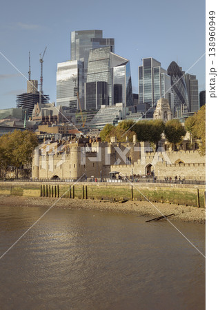 The weathered limestone of the Tower of London stands in silent vigil, anchoring a skyline of glass-crowned ambition. This historic fortress provides a tactile foundation for the gleaming vertical The weathered limestone of the Tower of London stands in silent vigil, anchoring a skyline of glass-crowned ambition. This historic fortress provides a tactile foundation for the gleaming vertical 138960949