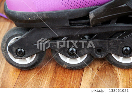 A close-up of black violet roller skates standing indoors. The concept of an active lifestyle, sports, outdoor activities, and fitness. A close-up of black violet roller skates standing indoors. The concept of an active lifestyle, sports, outdoor activities, and fitness. 138961021
