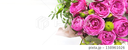 Close-up bouquet of pink peony roses with green leaves in elegant packaging. Botanical background with copy space for message and congratulations. A floral gift for a special occasion. Close-up bouquet of pink peony roses with green leaves in elegant packaging. Botanical background with copy space for message and congratulations. A floral gift for a special occasion. 138961026