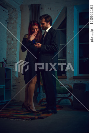 an proposing with engagement ring to surprised woman in cozy interior. an proposing with engagement ring to surprised woman in cozy interior. 138961163