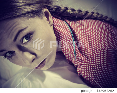 Sad depressed girl in bed gripping pillow Sad depressed girl in bed gripping pillow 138961262