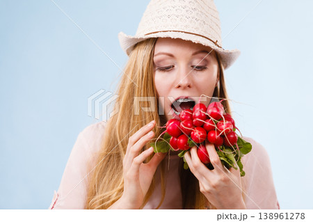 Happy woman biting radish Happy woman biting radish 138961278