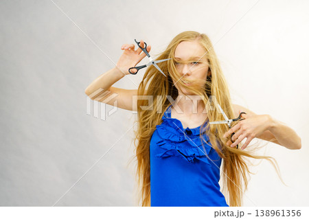 Young woman with scissors for haircutting 138961356