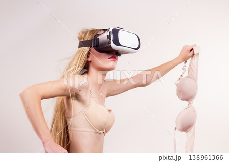 Girl in virtual reality goggles holds bra 138961366