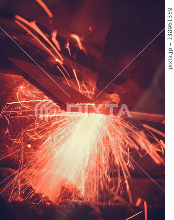 Laser cutting steel metal with bright sparks 138961389