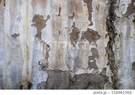 Weathered concrete wall with peeling plaster and water damage 138961568