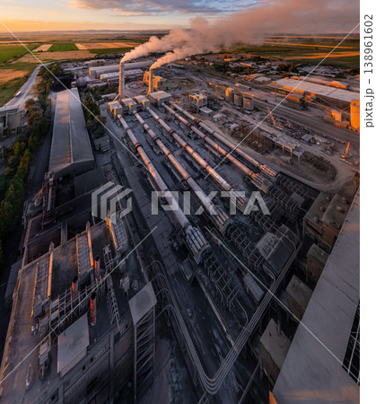aerial wide angle Industrial cement plant with smokestacks and agricultural fields at sunset 138961602