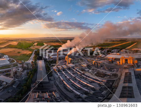 Industrial cement plant with smokestacks and agricultural fields at sunset Industrial cement plant with smokestacks and agricultural fields at sunset 138961603