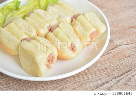 roll bread stuffing pork ham and cheese with fresh cos lettuce on plate 138961645