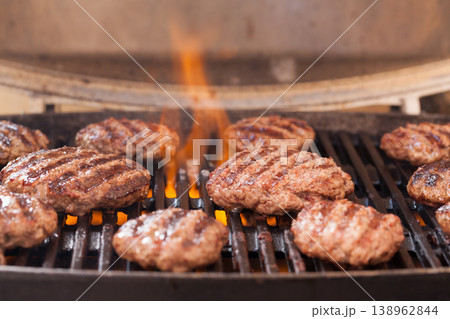 Burger patties grilling with fire and smoke 138962844