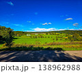 Panoramic view of a small town in a lush green valley at the foot of blue mountains. 138962988