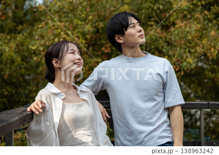 ベランダで外を見ている若い男女 138963242