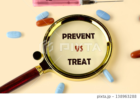 A magnifying glass highlights PREVENT vs TREAT surrounded by various medicine pills and a syringe on a light surface. This represents health choices 138963288