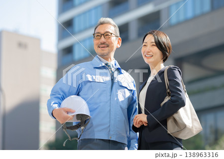 作業着を着た男性とスーツ姿の女性 作業着を着た男性とスーツ姿の女性 138963316