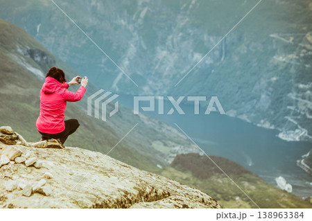 Tourist taking photo from Dalsnibba viewpoint Norway 138963384