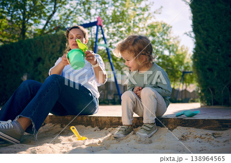 Mother Playing With Toddler Boy In Sandbox At Home Playground On Sunny Day 138964565