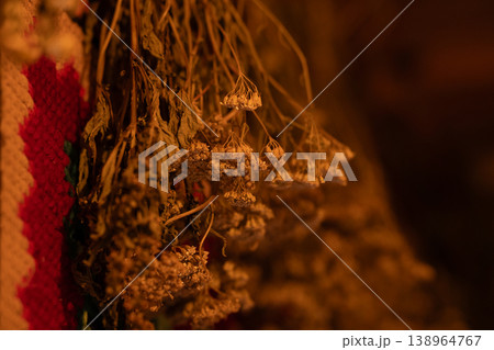 Dried Wildflowers and Herbs Hanging to Dry with Colorful Woven Textile Background 138964767