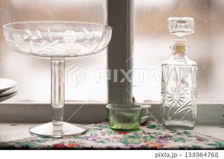 Elegant Glassware Set with Etched Bowl and Decanter on Window Sill with Floral Fabric Elegant Glassware Set with Etched Bowl and Decanter on Window Sill with Floral Fabric 138964768