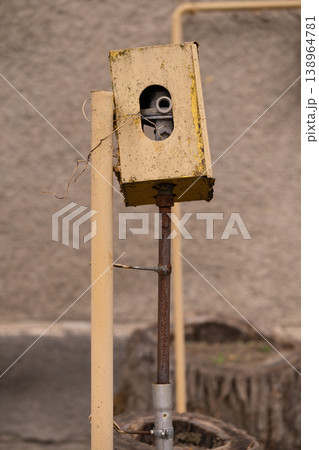 Old Rusty Metal Control Box with Exposed Wires on Industrial Stand against Concrete Wall Old Rusty Metal Control Box with Exposed Wires on Industrial Stand against Concrete Wall 138964781