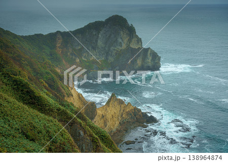 Muroran, Hokkaido, Japan - Oct 04 2024, panoramic aerial view of the picturesque Pacific ocean coast with sharp cliffs and high mountain slopes, in a storm, it's raining, at daytime, Muroran, Japan 138964874