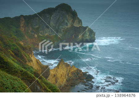 Muroran, Hokkaido, Japan - Oct 04 2024, panoramic aerial view of the picturesque Pacific ocean coast with sharp cliffs and high mountain slopes, in a storm, it's raining, at daytime, Muroran, Japan Muroran, Hokkaido, Japan - Oct 04 2024, panoramic aerial view of the picturesque Pacific ocean coast with sharp cliffs and high mountain slopes, in a storm, it's raining, at daytime, Muroran, Japan 138964876