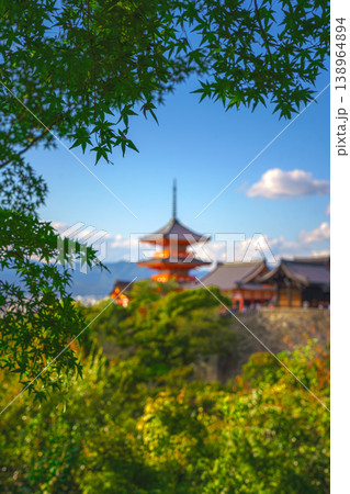Kyoto, Japan - Oct 11 2024, vertical view through foliage of Kiyomizu-Dera temple complex with a pagoda, with a clear blue sky and a forest in foreground, at daytime, blurred, Kyoto, Japan Kyoto, Japan - Oct 11 2024, vertical view through foliage of Kiyomizu-Dera temple complex with a pagoda, with a clear blue sky and a forest in foreground, at daytime, blurred, Kyoto, Japan 138964894